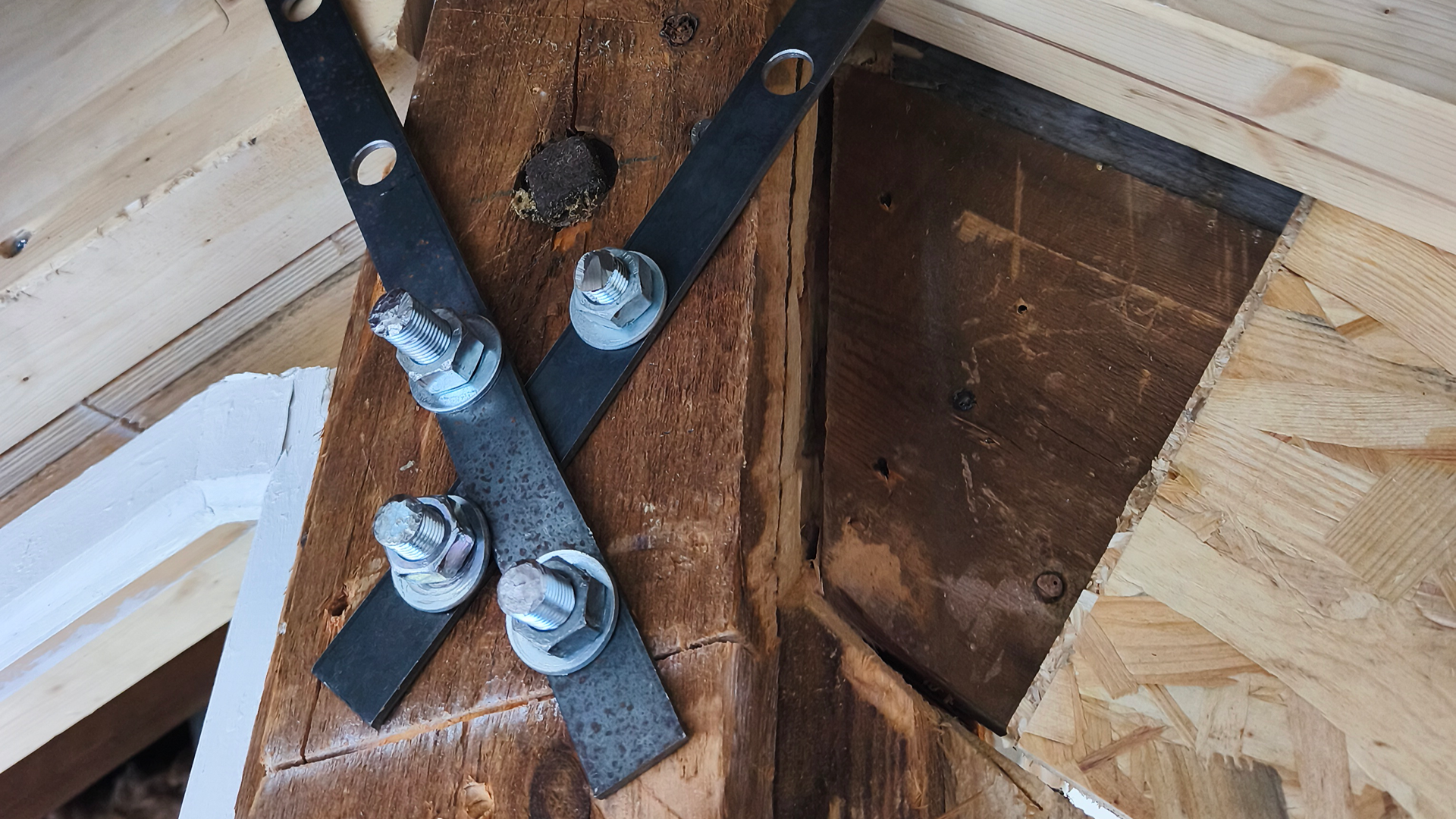 Éléments de structure en bois et métal à Nantes, AUSCULTATION DE L'EXISTANT, montrant un croisement de supports fixés avec des boulons.