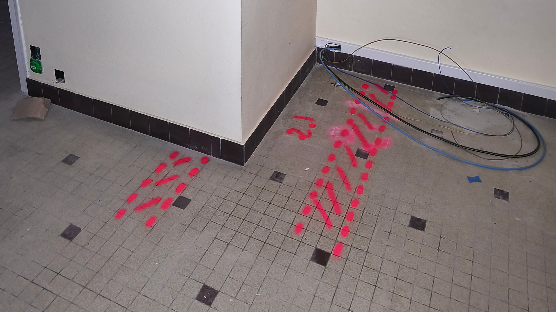 Marquages au sol en peinture rose dans un espace intérieur, indiquant des repères pour une auscultation technique à Nantes.